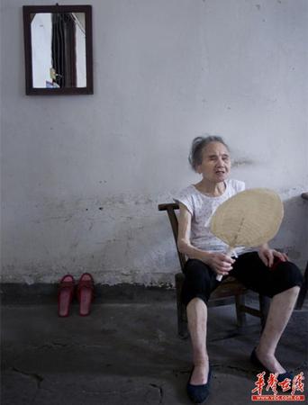 　90歲的王仲蓮如今已患有間歇性的老年癡呆，時而清醒、時而糊涂。圖為王仲蓮老人靜坐在屋內(nèi)，搖著蒲扇。