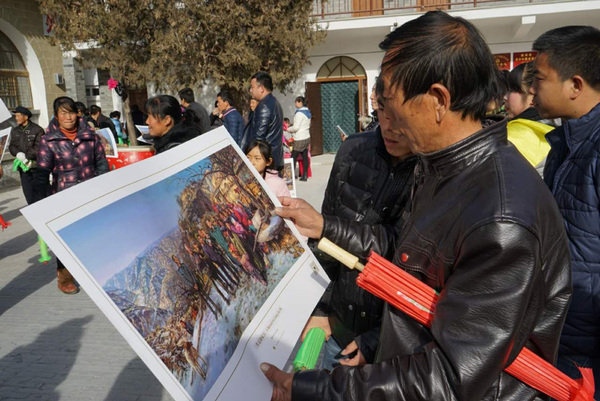 梁家河村民在觀賞《重返梁家河》的宣傳畫