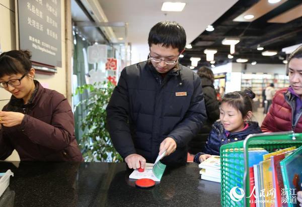 圖書管理員給新書加蓋杭州圖書館公章。