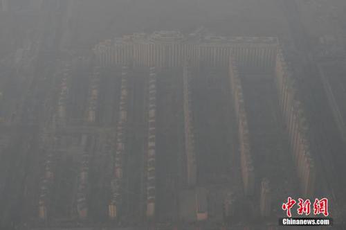 資料圖：2015年12月21日，北京上空航拍空氣重污染，地面建筑若隱若現(xiàn)。12月18日，北京再次發(fā)布紅色預(yù)警，12月19日7時至12月22日24時啟動空氣重污染紅色預(yù)警措施。實(shí)施機(jī)動車單雙號行駛、建議中小學(xué)幼兒園停課等措施。 <a target='_blank' href='http://www.chinanews.com/'>中新社</a>記者 廖攀 攝