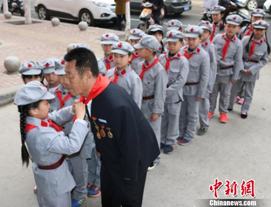 受谷殿明血雷鋒事跡的感染，雷鋒小標(biāo)兵為這位“活雷鋒”爺爺系上紅領(lǐng)巾?！」鶊@ 攝