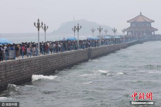 看海還是看人海？4月30日，青島棧橋的小清新氣息全無(wú)，只剩下緩慢挪動(dòng)的各位盡情享受無(wú)盡的海風(fēng)。 圖片來(lái)源：視覺(jué)中國(guó)