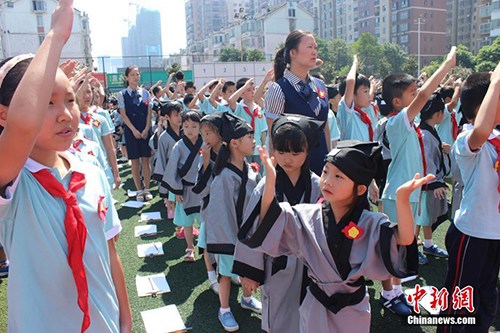 　　8月29日，長(zhǎng)沙市岳麓區(qū)一小學(xué)舉行開學(xué)典禮，一年級(jí)新生們身著漢服，在老師的帶領(lǐng)和高年級(jí)同學(xué)的幫助下完成了“開筆禮”。校方希望以此方式教育學(xué)生從小要立志、做好人，學(xué)會(huì)感恩老師，勇于表達(dá)。劉著之 攝