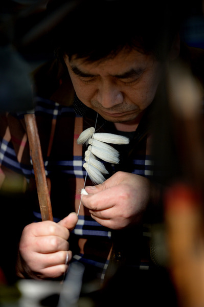 一位師傅在進(jìn)行捆頭工序的制作。