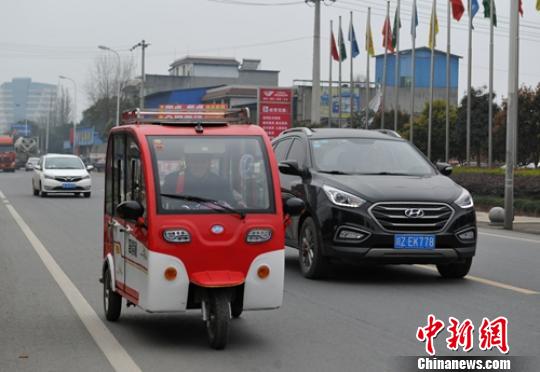 一位老者駕駛電動三輪車行駛在省道103線公路眉山段?！⒅铱?攝