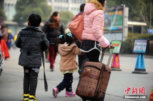 資料圖：2015年2月5日，2015年春運(yùn)第二天，江蘇揚(yáng)州市汽車西站迎來客流高峰，圖為家長帶著孩子在江蘇揚(yáng)州市汽車西站候車。 孟德龍 攝