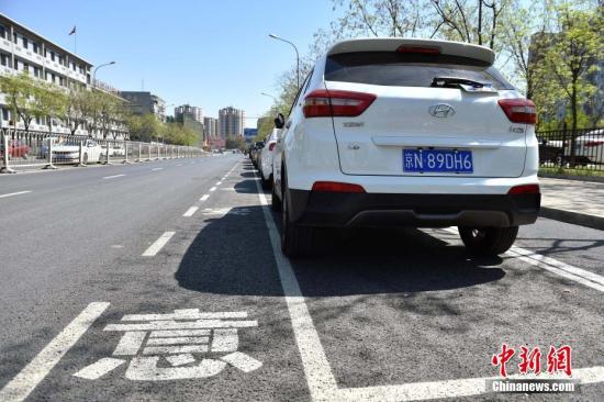 近日，北京市石景山蘋果園南路出現(xiàn)了一種新式路側(cè)停車位，位置從緊貼便道旁邊挪到了機(jī)動車道和非機(jī)動車道中間。據(jù)交管部門介紹，這樣的停車位在全市還屬首創(chuàng)，目的是為了解決停車難的同時保障非機(jī)動車的路權(quán)。新式路側(cè)停車位設(shè)置在路南側(cè)近30余個，位于兩條機(jī)動車道和一條非機(jī)動車道中間，停車位內(nèi)已經(jīng)都停滿了私家車，騎車人使用最外側(cè)的自行車專用道，與行駛的機(jī)動車隔離開來，互不影響。停車位左側(cè)還劃有一米左右寬的虛線邊框，提醒司機(jī)“注意安全”。<a target='_blank' href='http://www.chinanews.com/' >中新網(wǎng)</a>記者 金碩 攝