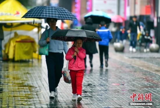 資料圖：9月24日，新疆烏魯木齊市降下秋雨，外出民眾打著雨傘快步前行。 <a target='_blank' href='http://www.chinanews.com/'>中新社</a>記者 劉新 攝