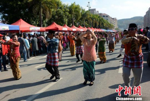 踩街隊伍在美食街上穿行表演，整個活動現(xiàn)場成為歌舞的海洋?！埥鸫āz