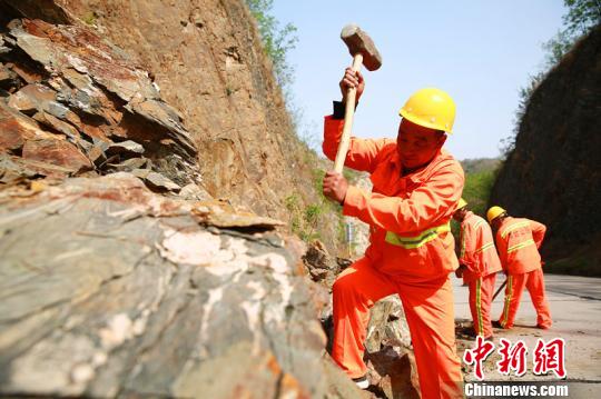 楊衛(wèi)東帶領(lǐng)工友們正在清理落石。　劉繼東 攝