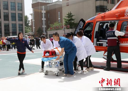 5月23日，遼寧省人民醫(yī)院完成中國(guó)東北首例異地航空醫(yī)療轉(zhuǎn)運(yùn)任務(wù)。圖為急救人員立即將患者抬上急救床?！≈烀饔?攝