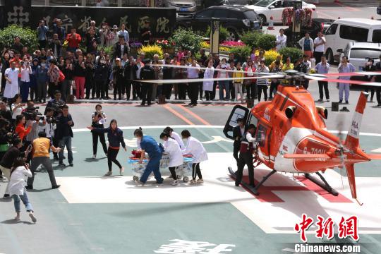 5月23日，遼寧省人民醫(yī)院完成中國(guó)東北首例異地航空醫(yī)療轉(zhuǎn)運(yùn)任務(wù)。圖為急救人員立即將患者抬上急救床?！≈烀饔?攝