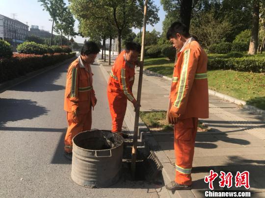 浙江省杭州市西湖區(qū)市政監(jiān)管科工作人員潘旭陽(左二)在清理淤泥?！『莒?攝