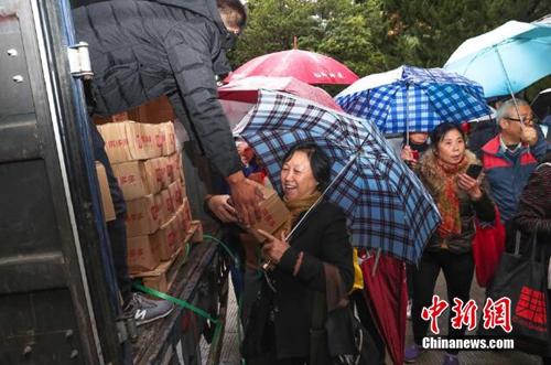 資料圖：上海百名居民在雨中排成一條長龍，領取剛到貨的秭歸臍橙。供圖