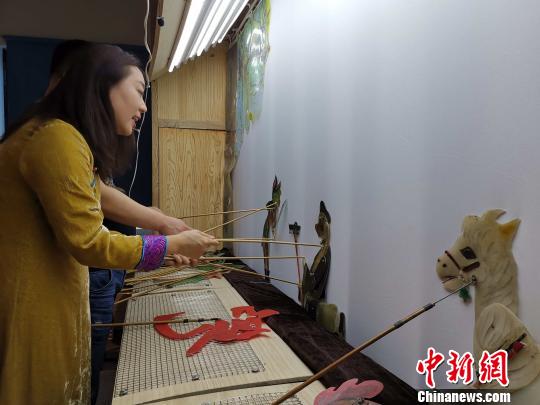 李娟藏在幕布后，繪聲繪色地為觀眾表演《西游記之孫悟空大戰(zhàn)蝎子精》?！≮w曉 攝