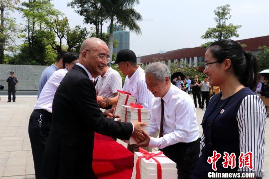 李德文董事長給學(xué)校老師贈送《論語新解》?！∥韩h 攝