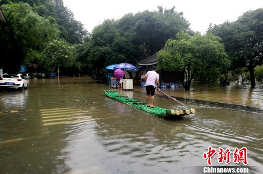 圖為桂林穿山公園部分被淹，附近民眾用竹箋出行?！√茐魬?攝