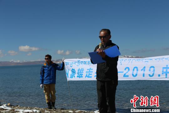 圖為團(tuán)隊成員在瑪旁雍錯湖邊讀詩?；顒臃焦﹫D