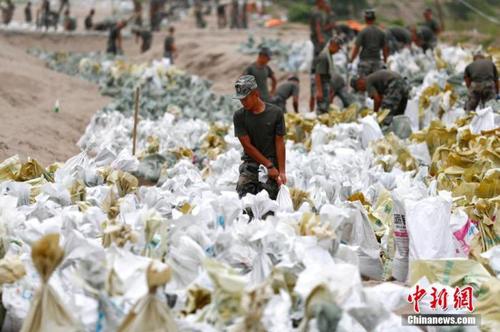 資料圖：7月25日，江西省九江市柴桑區(qū)江洲鎮(zhèn)北堤，中國人民解放軍第71集團軍某部官兵正在為防洪備料。